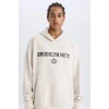 Defacto D6711 Bej DeFactoFit NBA Brooklyn Nets Oversize Geniş Kalıp Kapüşonlu Sırt Baskılı Skuba Dalgıç Kumaş Sweatshirt