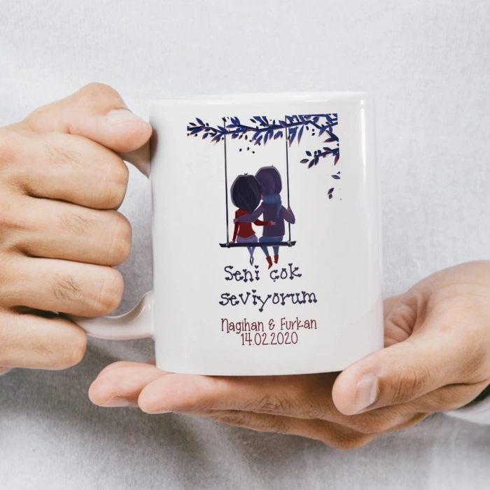 Altın renkli çerçeve içinde, uçan kalplerden oluşan kalp figürü bulunan kupa baskısı.