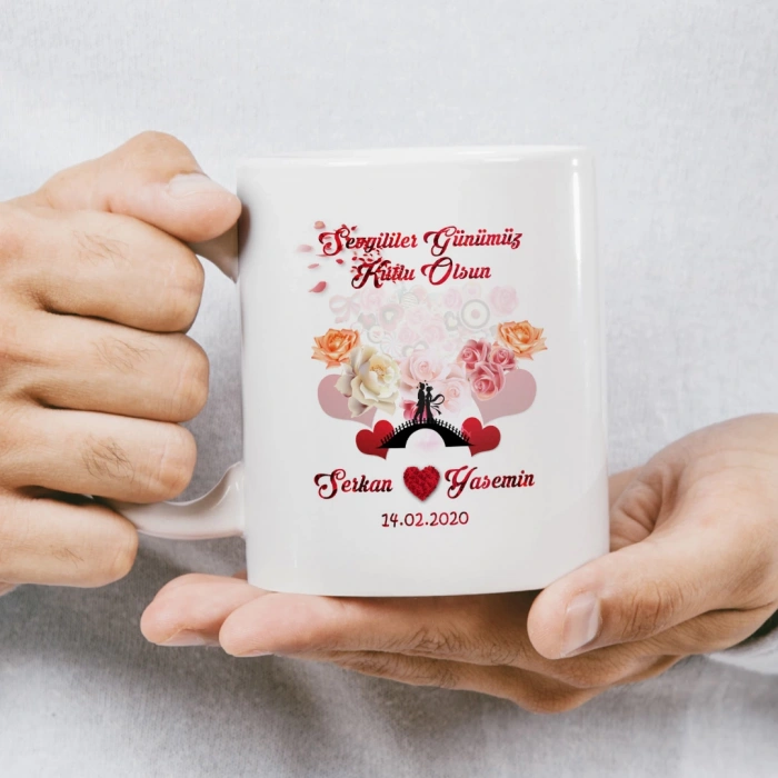 Öpüşen karikatür çift ve gül yapraklarından kalp figürü bulunan kupa baskısı.