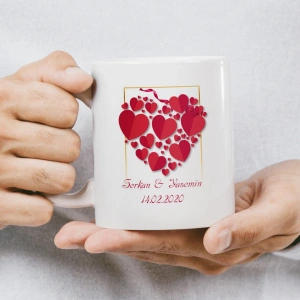 Kalp ve balonlarla çevrili, birbirini öpen karikatür çiftin bulunduğu kupa baskısı.