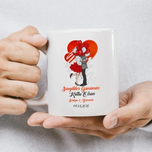 Öpüşen karikatür çift ve etraflarında kalplerin yer aldığı kupa baskısı.