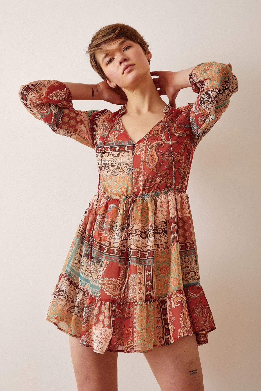 فستان قصير مصمم بياقة V ونقوشات بنيّة