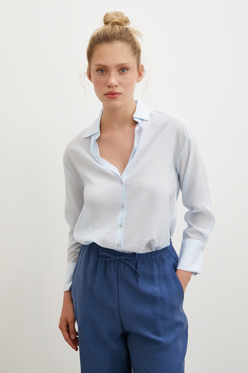 قميص بياقة على شكل V باللون الأزرق