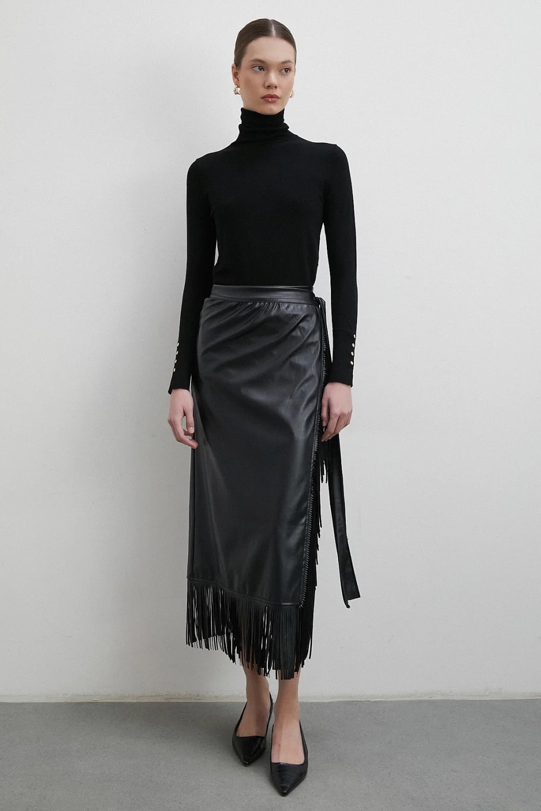 تنورة جلدية بتطريز وأطراف مزينة بالشراشيب باللون الأسود