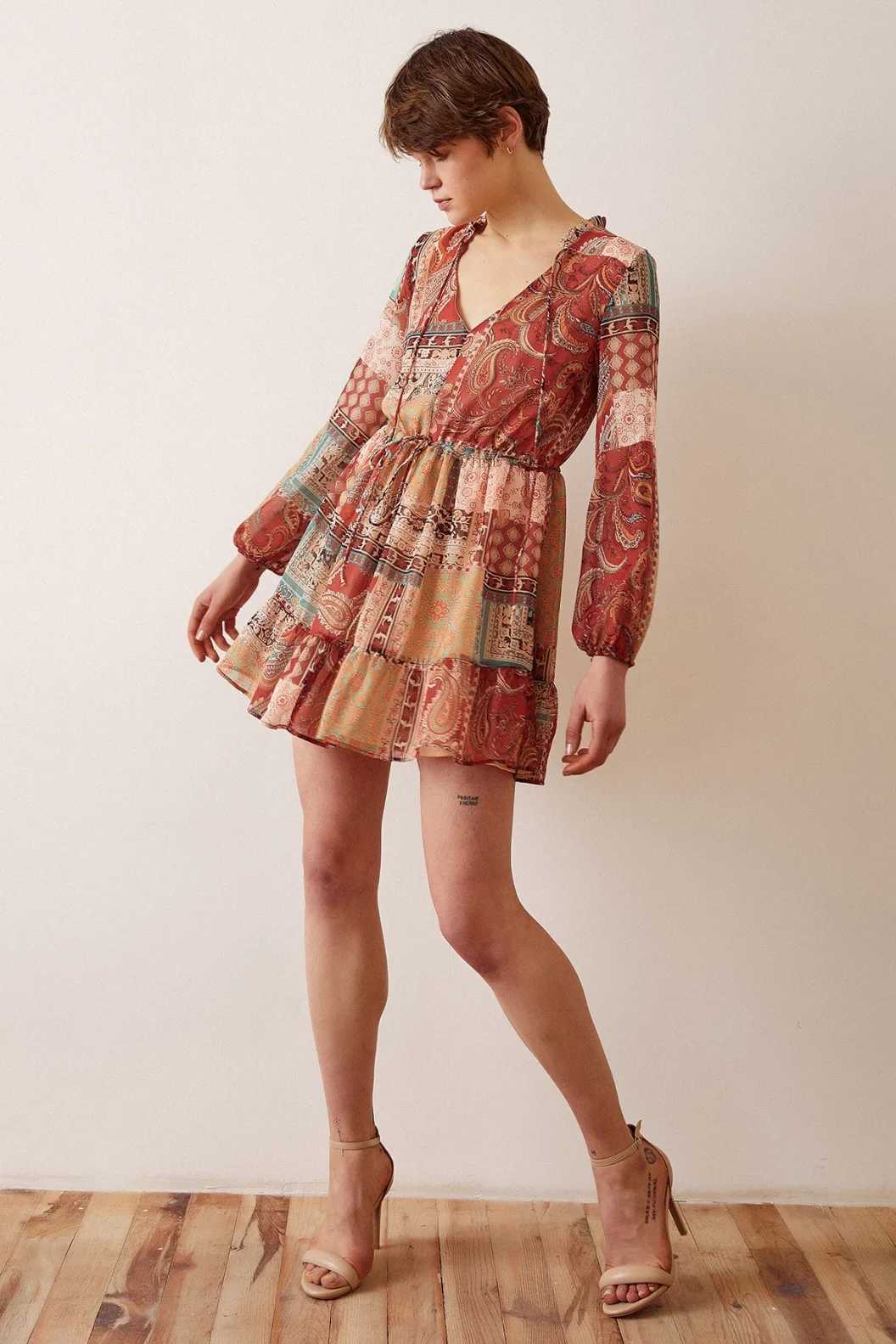 فستان قصير مصمم بياقة V ونقوشات بنيّة