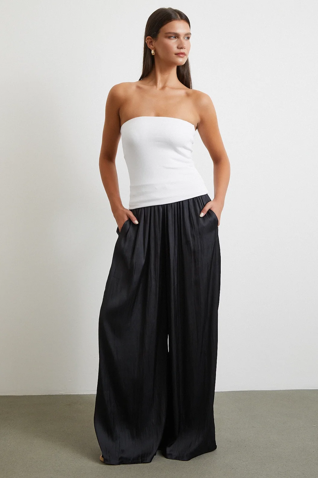 بنطلون أسود بخصر مطاطي وأطراف واسعة مزمومة