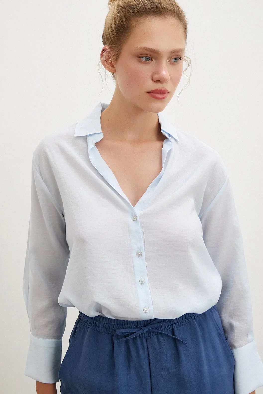 قميص بياقة على شكل V باللون الأزرق