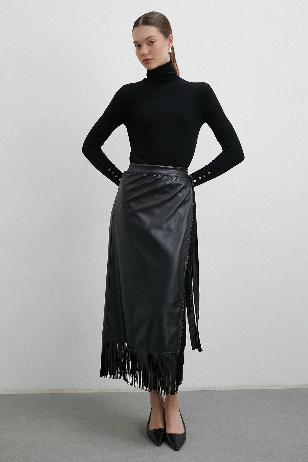 تنورة جلدية بتطريز وأطراف مزينة بالشراشيب باللون الأسود