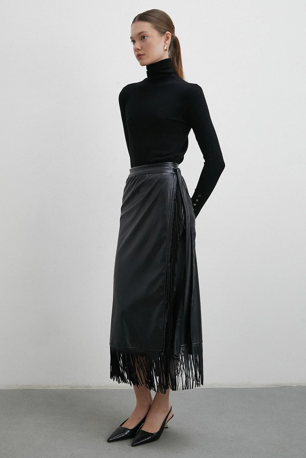 تنورة جلدية بتطريز وأطراف مزينة بالشراشيب باللون الأسود