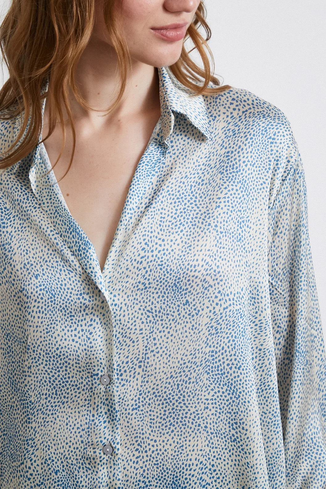 قميص حرير برقبة V مزين بنمط موجة لونه أزرق