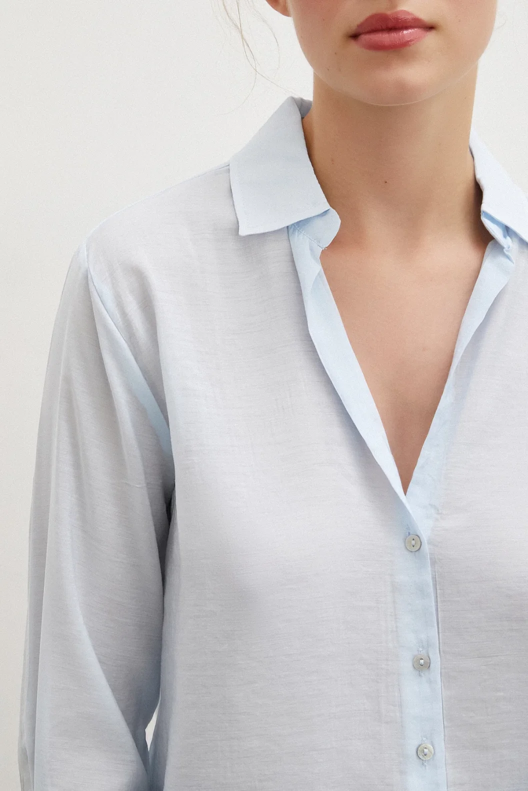 قميص بياقة على شكل V باللون الأزرق