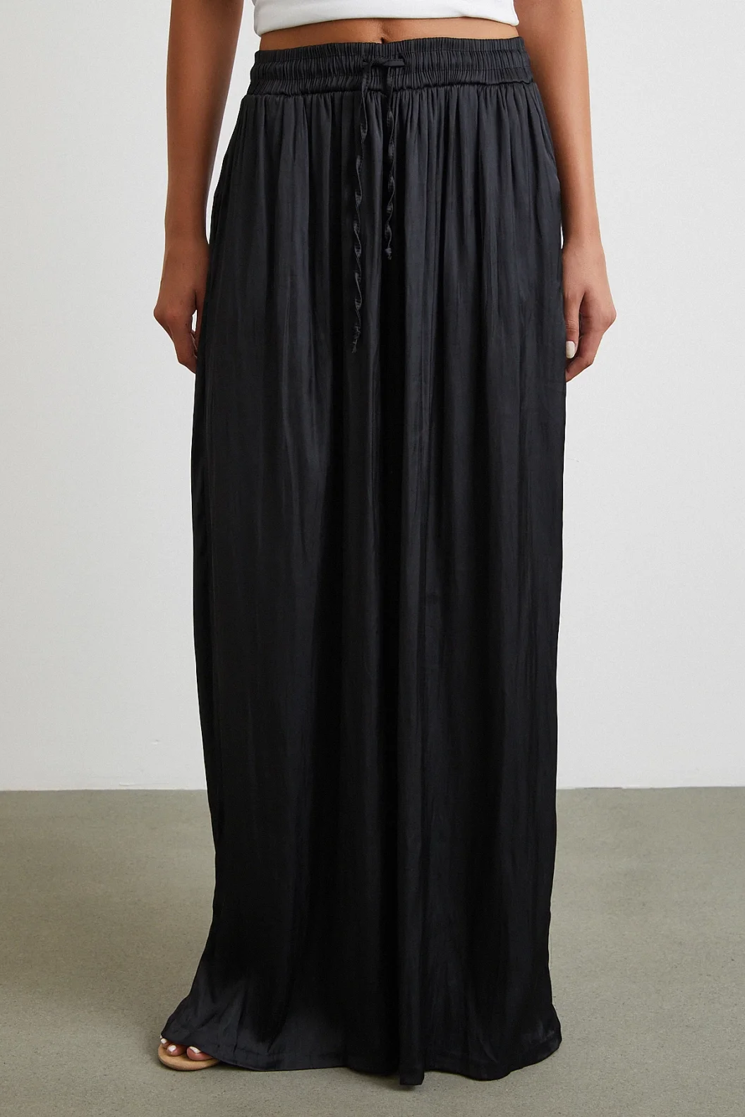 بنطلون أسود بخصر مطاطي وأطراف واسعة مزمومة