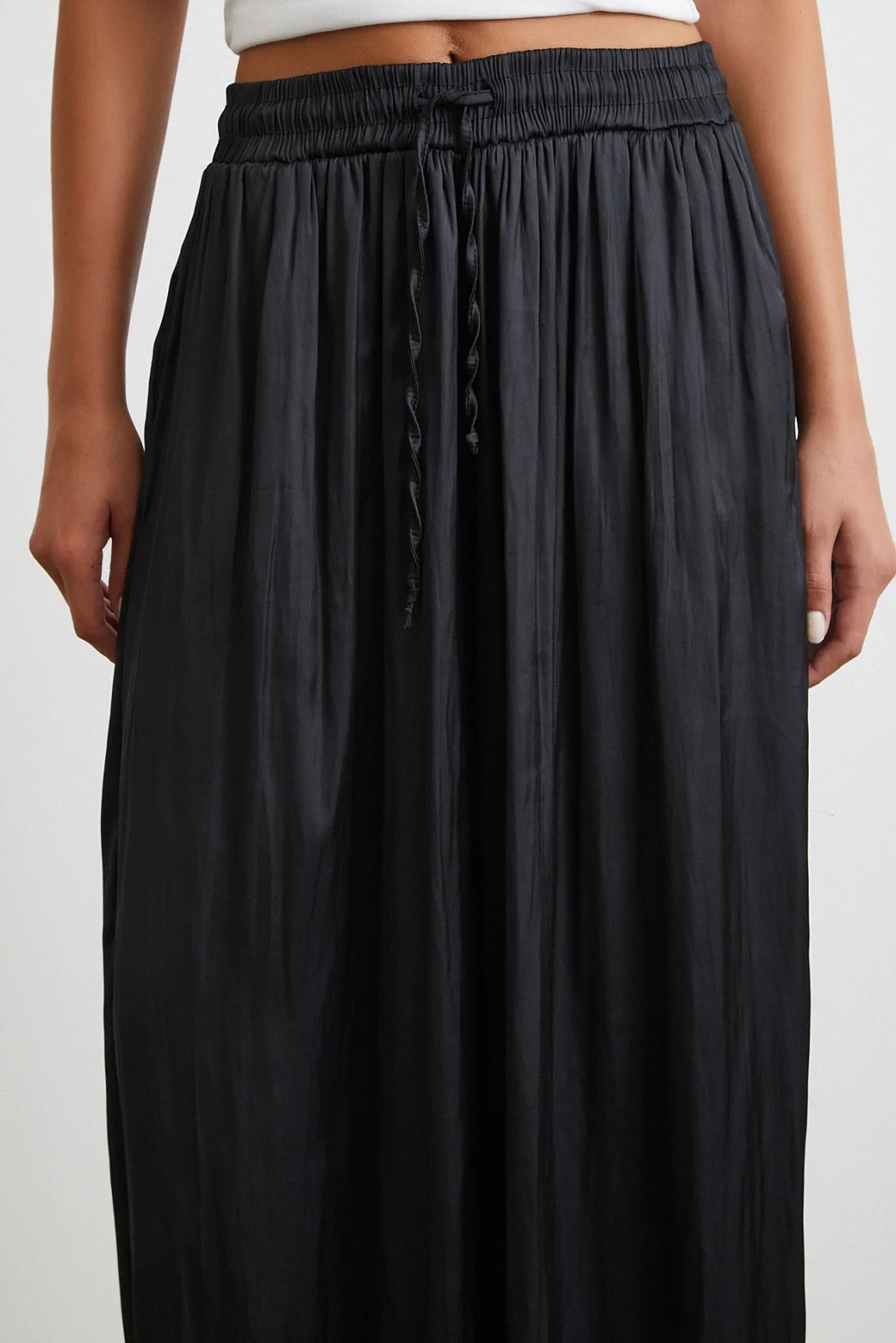 بنطلون أسود بخصر مطاطي وأطراف واسعة مزمومة