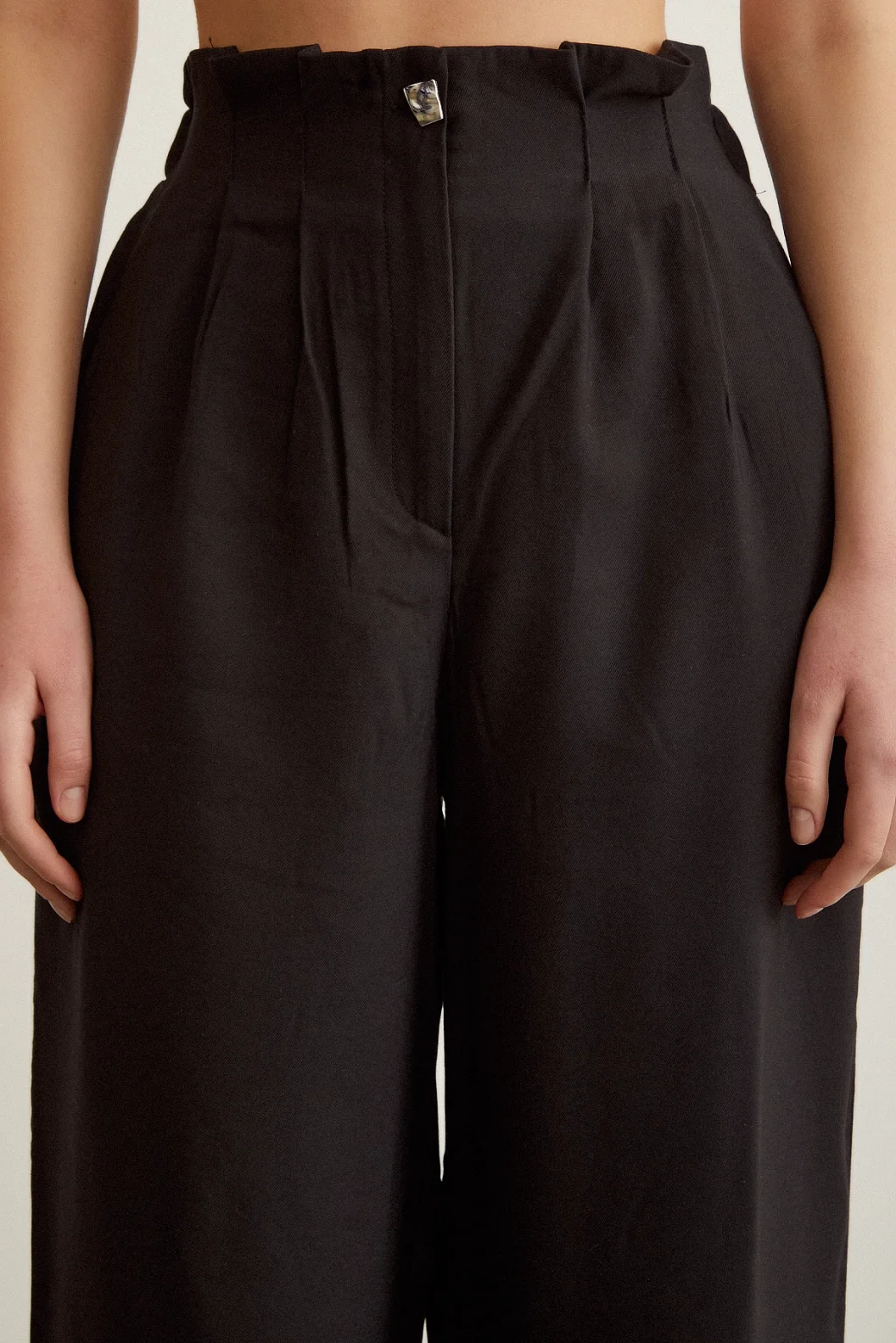 بنطال أسود مع تفاصيل أزرار مطاطية وتنورة مجسمة