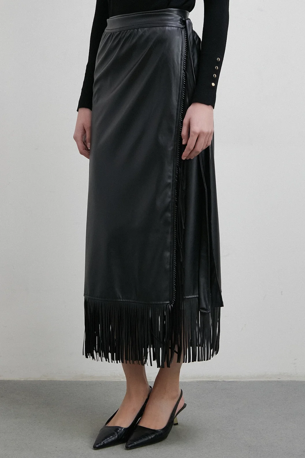 تنورة جلدية بتطريز وأطراف مزينة بالشراشيب باللون الأسود