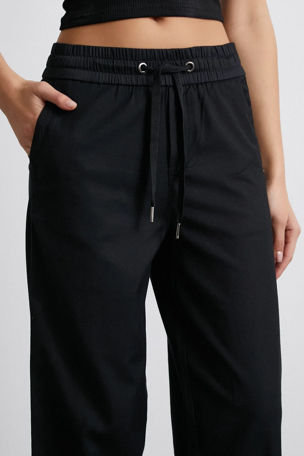 بنطلون أسود بخصر مطاطي وأطراف مطوية