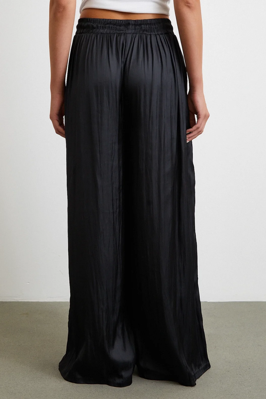 بنطلون أسود بخصر مطاطي وأطراف واسعة مزمومة