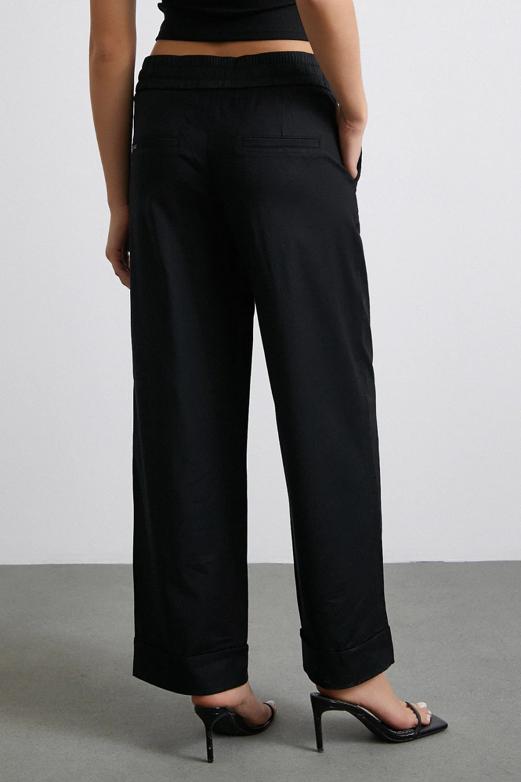 بنطلون أسود بخصر مطاطي وأطراف مطوية