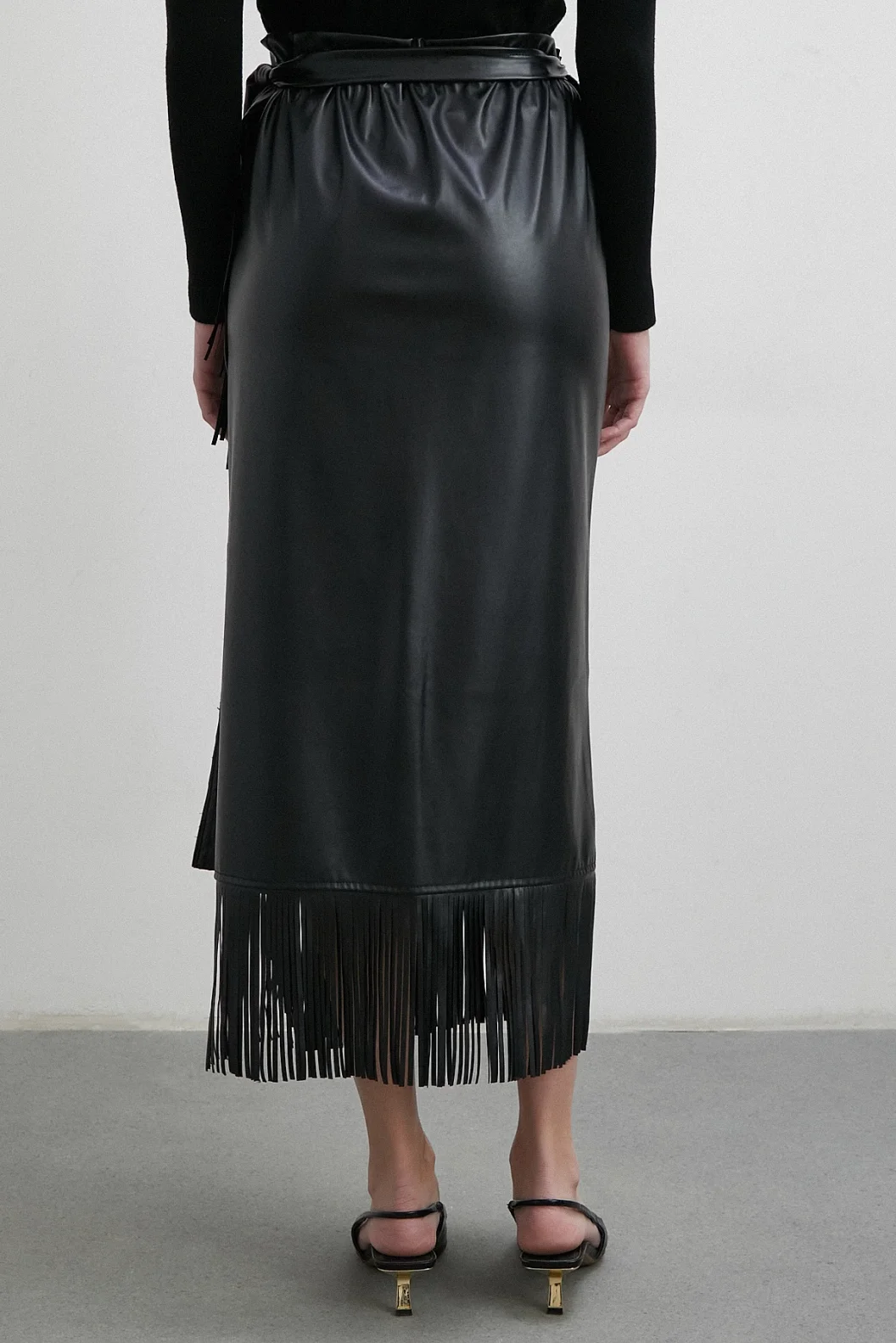 تنورة جلدية بتطريز وأطراف مزينة بالشراشيب باللون الأسود