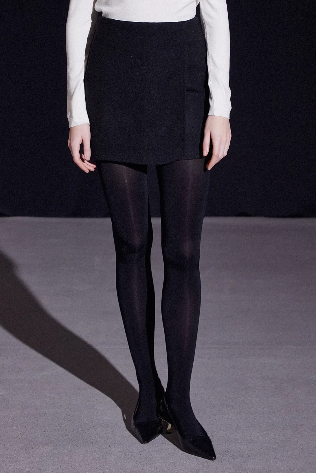 التنورة السترة ذات التصميم الأمامي العالي باللون الأسود